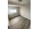 This bedroom features a window for natural light and plank flooring throughout at 521 10Th St, Fort Lupton, CO 80621