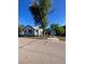 Charming single-story home with white siding, a blue trim, a detached garage, and a large tree at 521 10Th St, Fort Lupton, CO 80621