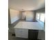 Open-concept living room with island bar, gray floors and large windows at 521 10Th St, Fort Lupton, CO 80621