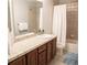 Clean bathroom, featuring a large vanity with tile countertops, a shower/tub combo, and updated fixtures at 6588 S Sheridan Loop, Littleton, CO 80123