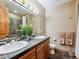 Bathroom with wood cabinets, double sinks, tile flooring, large mirror, and tiled shower at 26886 Evergreen Springs Rd, Evergreen, CO 80439
