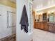 Spacious bathroom with tiled walk-in shower, glass block window and double vanity with wood cabinets at 26886 Evergreen Springs Rd, Evergreen, CO 80439