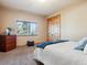 Comfortable bedroom with natural light, featuring carpeted floors and a closet with wood doors at 26886 Evergreen Springs Rd, Evergreen, CO 80439