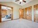 Light and airy carpeted bedroom with wood trim and doors, ceiling fan and walk in closets at 26886 Evergreen Springs Rd, Evergreen, CO 80439