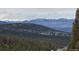 Beautiful mountain vista with snowcapped peaks on a treelined horizon at 26886 Evergreen Springs Rd, Evergreen, CO 80439