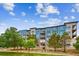 Modern apartment building with blue and brick exterior and landscaping at 487 Interlocken Blvd # 304, Broomfield, CO 80021