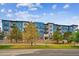 Modern apartment building with blue and brick exterior and landscaping at 487 Interlocken Blvd # 304, Broomfield, CO 80021