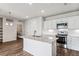 Modern kitchen with island, white cabinets, stainless steel appliances, and laundry area at 487 Interlocken Blvd # 304, Broomfield, CO 80021