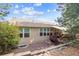 Home's backyard boasts a ground level deck with mature landscaping and stone retaining wall at 1026 Deer Clover Way, Castle Pines, CO 80108