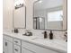 Bathroom featuring double sink vanity with white marble countertop and two large square framed mirrors at 1026 Deer Clover Way, Castle Pines, CO 80108