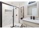 Bathroom featuring white vanity, contemporary shower with dark metal frame, and modern mirror at 1026 Deer Clover Way, Castle Pines, CO 80108