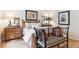Bright bedroom featuring light hardwood floors, neutral paint, wood accents, and stylish decor at 1026 Deer Clover Way, Castle Pines, CO 80108