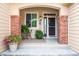 Inviting front porch with brick accents, a decorative window, and space for seating and potted plants at 1026 Deer Clover Way, Castle Pines, CO 80108
