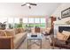 Inviting living room with hardwood floors, fireplace, ceiling fan, and large windows at 1026 Deer Clover Way, Castle Pines, CO 80108