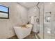 Modern bathroom with marble tile, freestanding tub, and glass enclosed shower at 3550 Eudora St, Denver, CO 80207