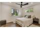 Minimalist bedroom design with a comfortable bed, modern ceiling fan, wood floors and two large windows at 3550 Eudora St, Denver, CO 80207