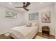 Comfortable bedroom with a bed, modern ceiling fan, wood floors, modern decor, and two windows at 3550 Eudora St, Denver, CO 80207