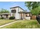 Charming two-story home features a front yard, balcony, and freshly painted white brick exterior at 3550 Eudora St, Denver, CO 80207