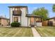 Charming two-story home features a front yard, balcony, and freshly painted white brick exterior at 3550 Eudora St, Denver, CO 80207