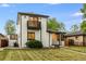 This two-story home features painted brick, a balcony, manicured lawn, and black trim at 3550 Eudora St, Denver, CO 80207