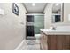 Modern bathroom featuring a wood vanity, glass shower, and sleek fixtures at 724 Ursula St, Aurora, CO 80011