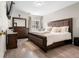 Comfortable bedroom with a plush bed, wood floors, and dark wood furniture at 724 Ursula St, Aurora, CO 80011