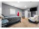 Cozy bedroom with a bed, wall-mounted TV, and carpet flooring with light-grey paint at 724 Ursula St, Aurora, CO 80011