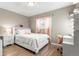 Cozy bedroom with a white bed, desk, and light pink curtains with wood floors at 724 Ursula St, Aurora, CO 80011