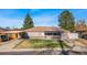 Charming single-story home with a covered front porch, attached garage and carport on a sunny day at 724 Ursula St, Aurora, CO 80011