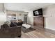 Comfortable living room featuring hardwood floors, modern decor, and a large TV, creating a welcoming space at 724 Ursula St, Aurora, CO 80011