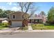 Charming home with a mature tree, brick accents, and an attached two-car garage at 3970 S Syracuse Way, Denver, CO 80237