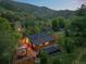 Log home nestled in a lush mountain landscape with a patio and outbuildings at 2874 Se Grapevine Rd, Idledale, CO 80453