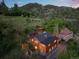 Aerial view of log home with fenced yard and detached outbuildings at 2874 Se Grapevine Rd, Idledale, CO 80453