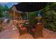 Outdoor patio area at dusk with decorative string lights and a cozy seating area at 2874 Se Grapevine Rd, Idledale, CO 80453