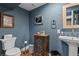 Powder room with dark blue walls, hardwood floors, pedestal sink and decorative accents at 2874 Se Grapevine Rd, Idledale, CO 80453