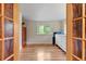Sunlit bedroom showcases hardwood floors and large windows with scenic views of the surrounding greenery at 2874 Se Grapevine Rd, Idledale, CO 80453