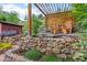 Backyard seating area under pergola with stone retaining wall at 2874 Se Grapevine Rd, Idledale, CO 80453