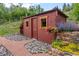 Red storage shed with flower boxes and rock landscaping at 2874 Se Grapevine Rd, Idledale, CO 80453