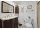 Cozy bathroom with a white vanity and sink, dark wood cabinets, and ceramic tile flooring at 4641 W Ponds Cir, Littleton, CO 80123