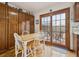 Dining Area with a wooden table, white chairs, wood-paneled walls and outdoor access to a stone patio at 4641 W Ponds Cir, Littleton, CO 80123