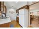 Practical kitchen layout with white appliances, wooden cabinetry and laminate flooring at 4641 W Ponds Cir, Littleton, CO 80123