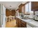 Kitchen area featuring wooden cabinetry, stainless steel sink and table with chairs adjacent to window light at 4641 W Ponds Cir, Littleton, CO 80123