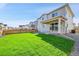 A well-maintained backyard features a lush green lawn, fenced perimeter, and covered patio at 4644 Hatcher Dr, Brighton, CO 80601