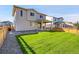 A well-maintained backyard features a lush green lawn, fenced perimeter, and covered patio at 4644 Hatcher Dr, Brighton, CO 80601