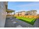 Large grassy backyard with a stone step walkway and a covered porch at 4644 Hatcher Dr, Brighton, CO 80601