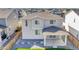 Aerial view of a two-story home with gray siding, stone accents, a two-car garage, and a well-kept lawn at 4644 Hatcher Dr, Brighton, CO 80601