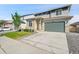 Two-story home with a driveway, green lawn, stone veneer, and two-car garage at 4644 Hatcher Dr, Brighton, CO 80601