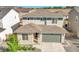 Aerial view of a two-story home with gray siding, stone accents, a two-car garage, and a well-kept lawn at 4644 Hatcher Dr, Brighton, CO 80601