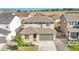 Aerial view of a two-story home with gray siding, stone accents, a two-car garage, and a well-kept lawn at 4644 Hatcher Dr, Brighton, CO 80601