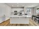 Bright kitchen with a large center island, stainless appliances, and wood laminate floors at 4644 Hatcher Dr, Brighton, CO 80601